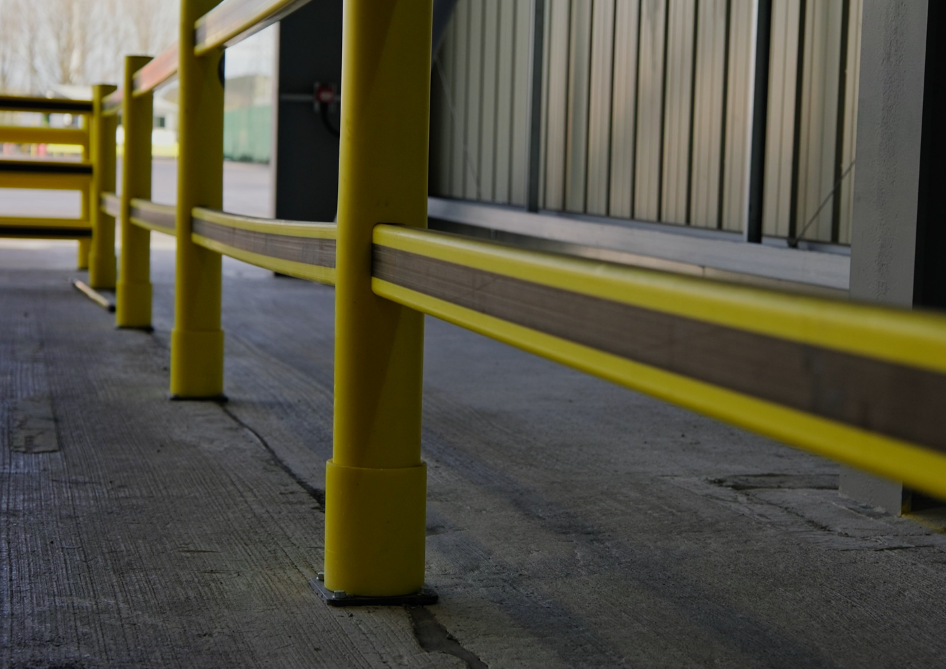 Polymer pedestrian barriers creating safe walkway segregation in warehouse facility