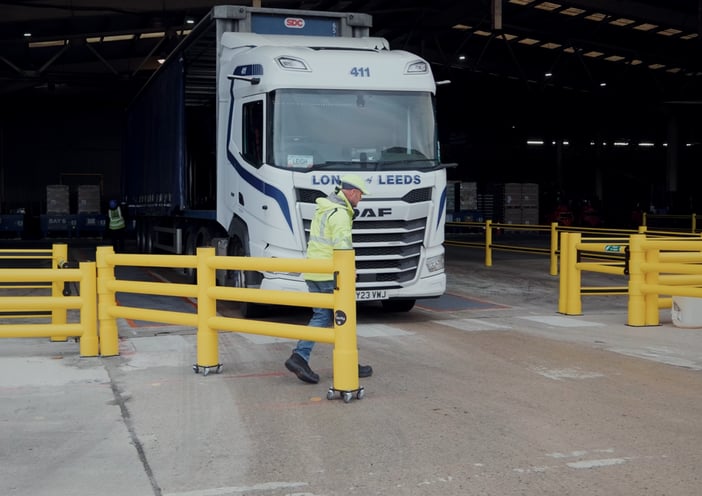 Warehouse banksman guiding HGV driver onto loading bay UK site