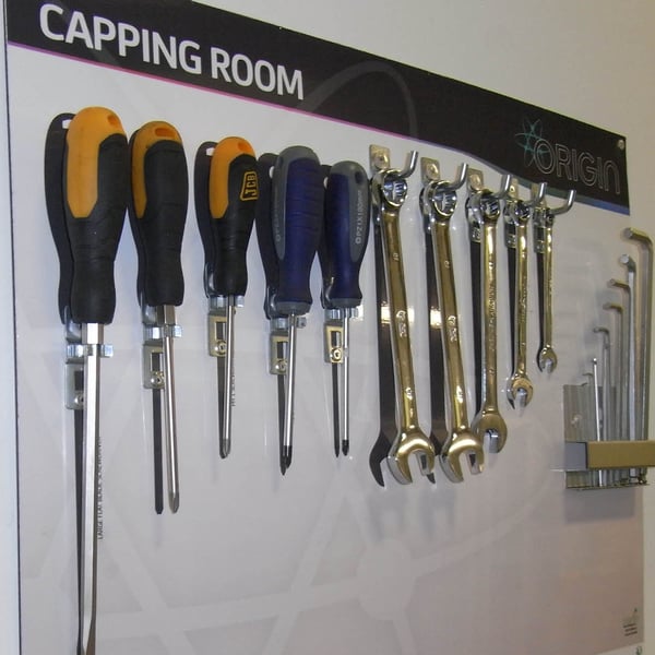 Shadow board with foam cut-outs showing tool organisation in warehouse with colour-coded visual management system