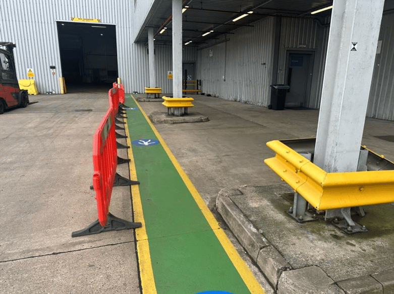 Substandard plastic safety barriers in external warehouse showing inadequate pedestrian protection