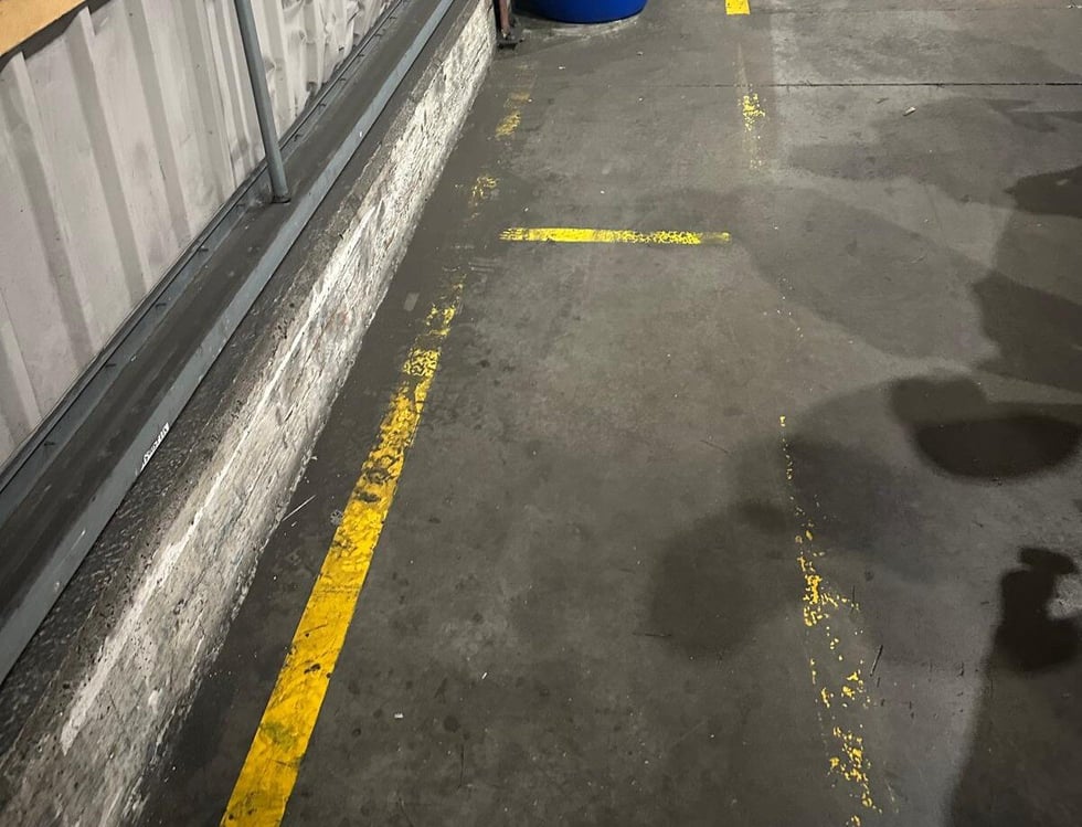 Worn painted floor markings for pedestrian walkway
