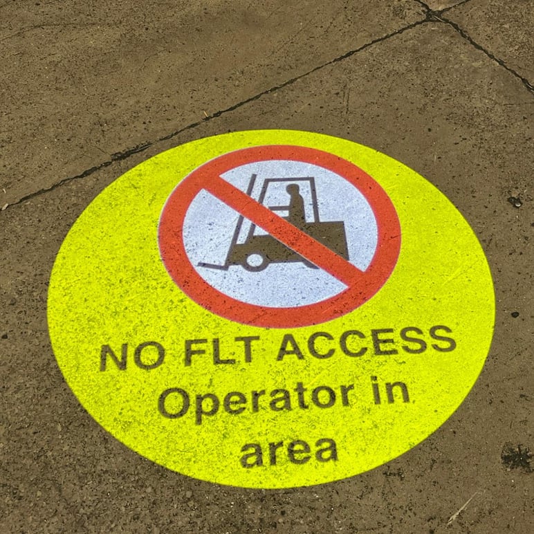 LED projected floor sign warning FLT drivers of pedestrian operator in warehouse aisle, UK facility
