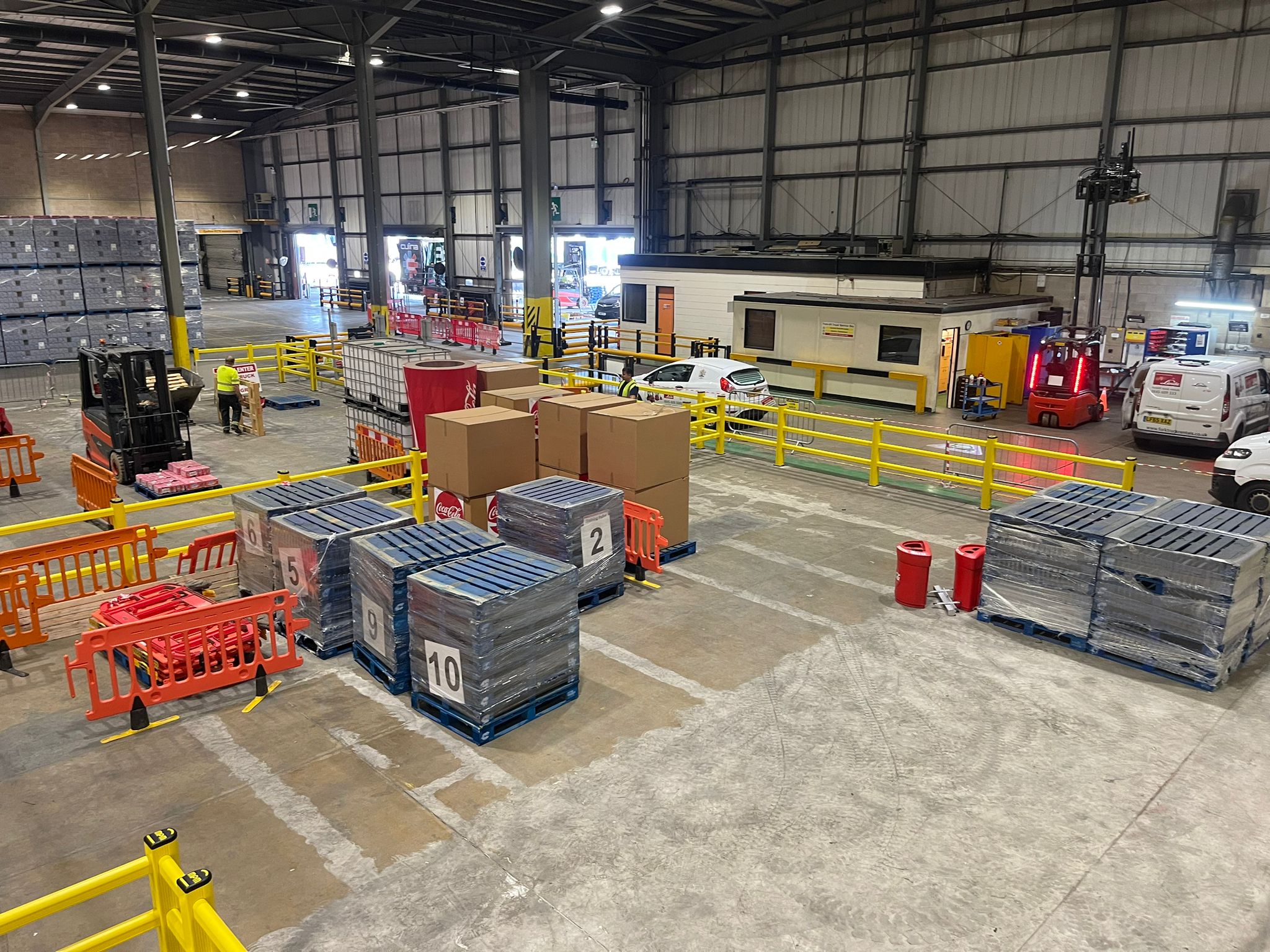 Yellow polymer pedestrian safety barriers protecting walkway in modern warehouse