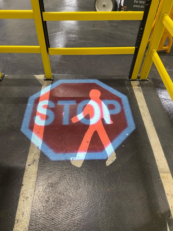 LED projected pedestrian crossing with stop signage in warehouse setting