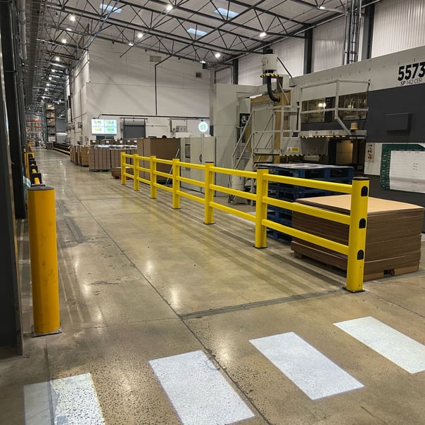 LED projected floor walkway alongside polymer safety barriers in UK warehouse