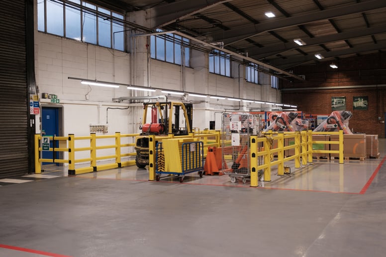 Flexible polymer safety barriers protecting warehouse racking from forklift collisions