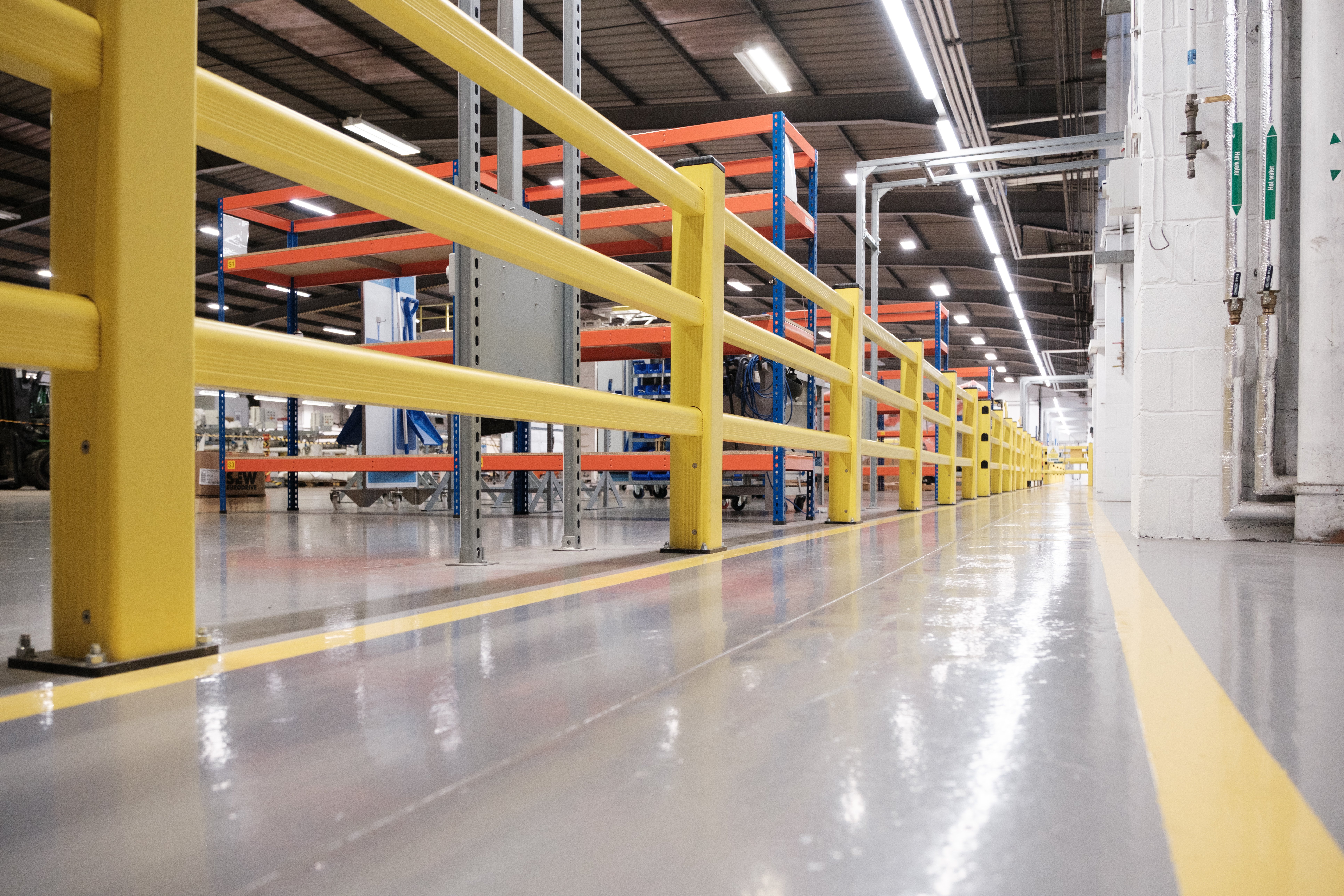 Polymer barriers creating compliant pedestrian segregation route in industrial warehouse