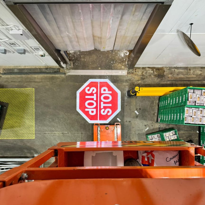 Warehouse floor stop sign marking at vehicle and pedestrian intersection point