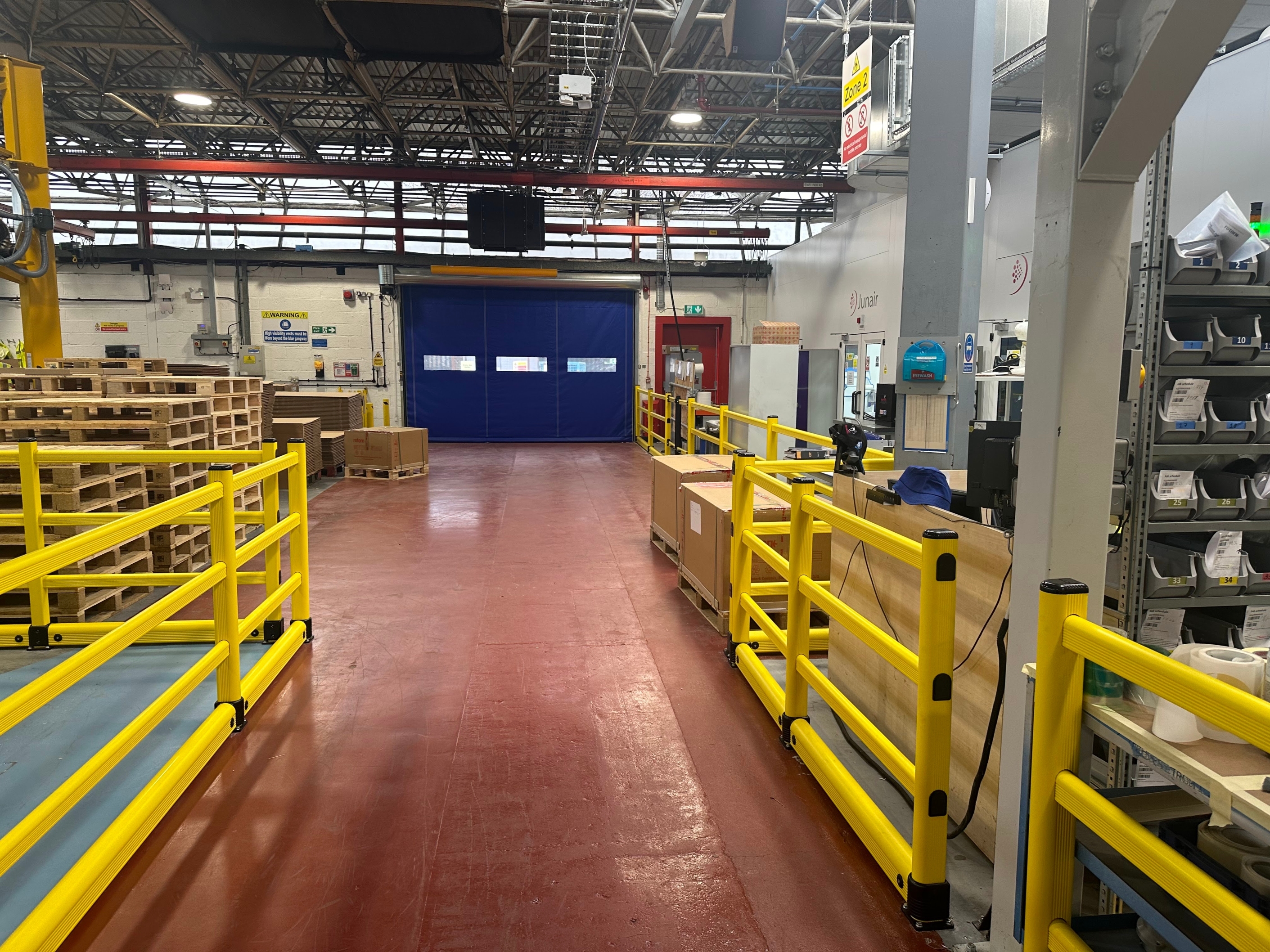 Yellow polymer safety barriers positioned along pedestrian walkway in UK warehouse