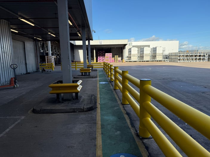 Warehouse yard showing marked vehicle routes and protected pedestrian crossing point