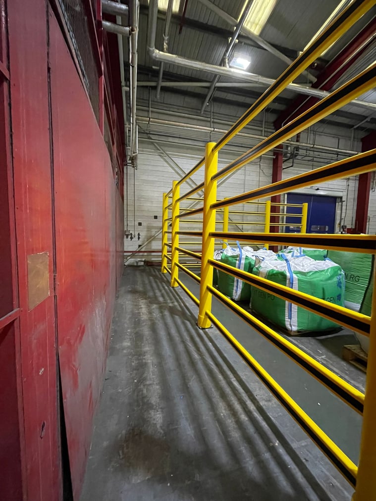 Topple barrier protecting staff from toppling stock in a food plant