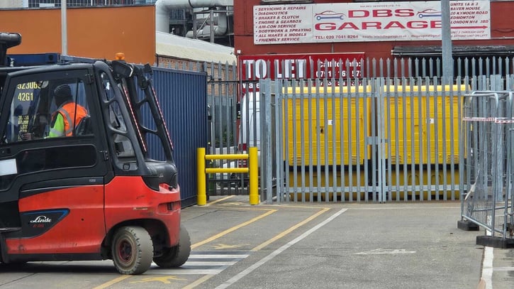 Forklift truck operating in an outdoor yard near a segregated pedestrian route