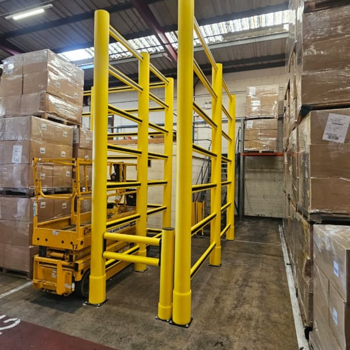 •	High-level topple barrier protecting a pedestrian walkway from stock stacked at height