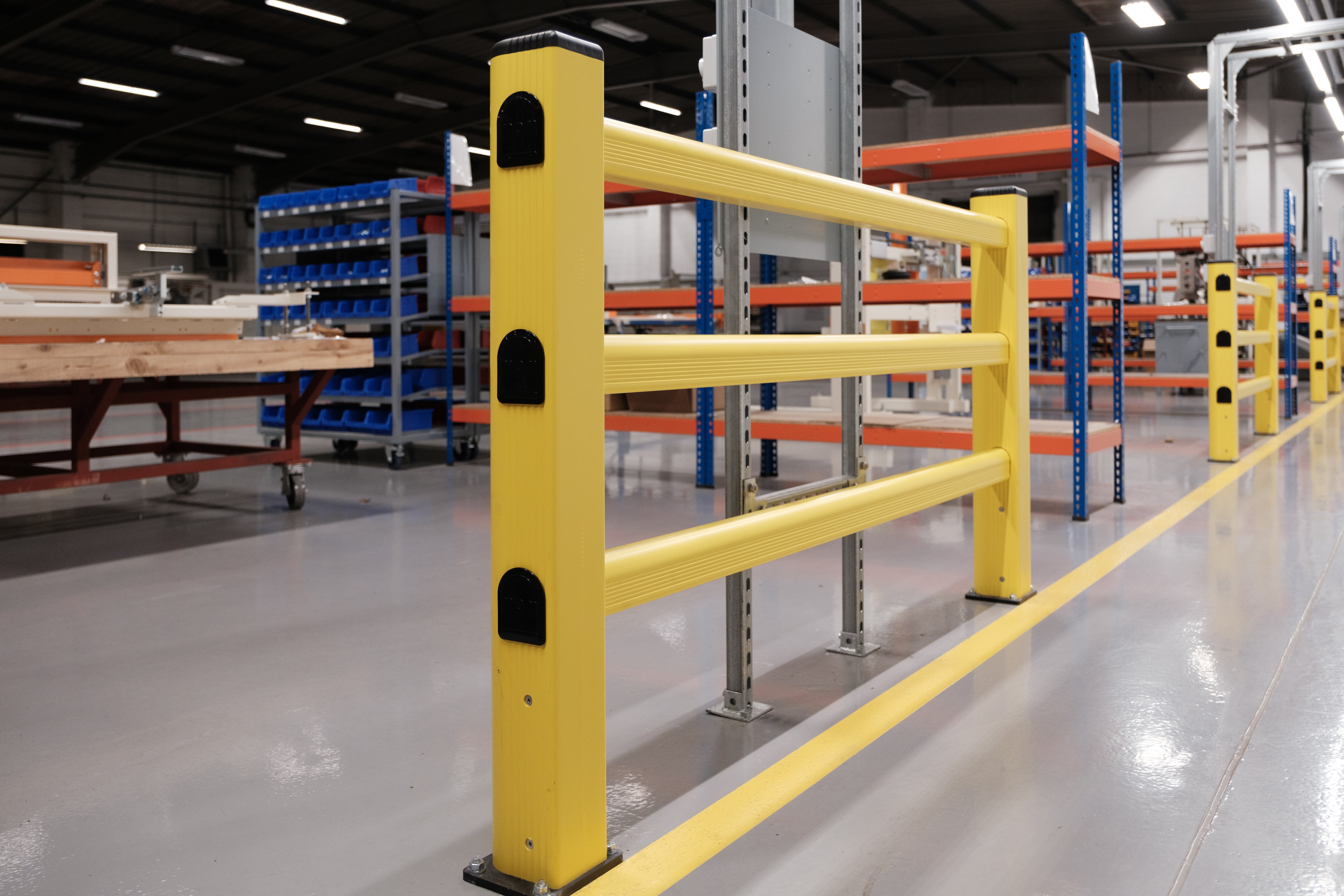 Modular polymer safety barriers with high-visibility yellow railings separating pedestrian zone