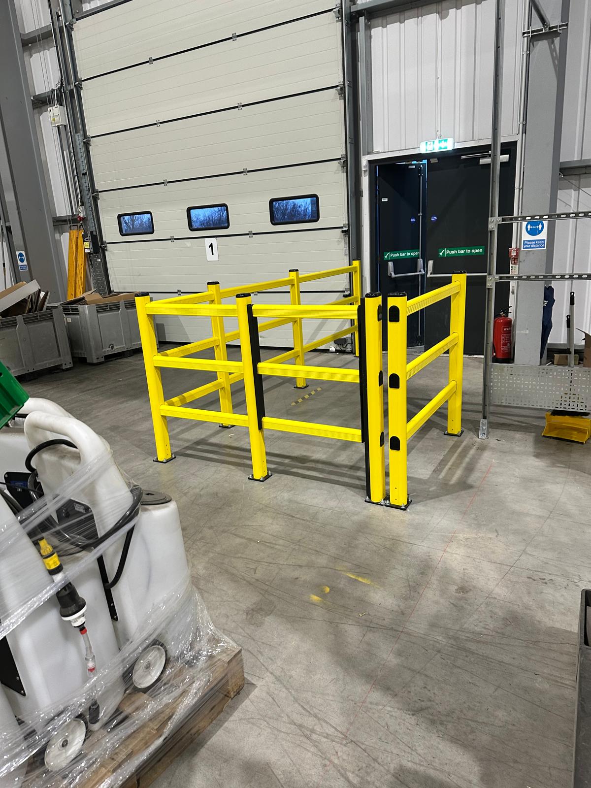 High-visibility safety gate separating a pedestrian route from FLT traffic in a factory