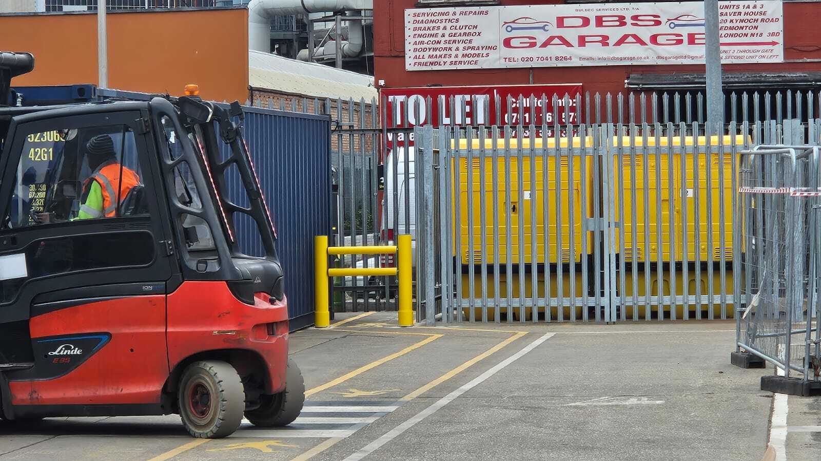 Forklift truck operating in an outdoor yard near a segregated pedestrian route