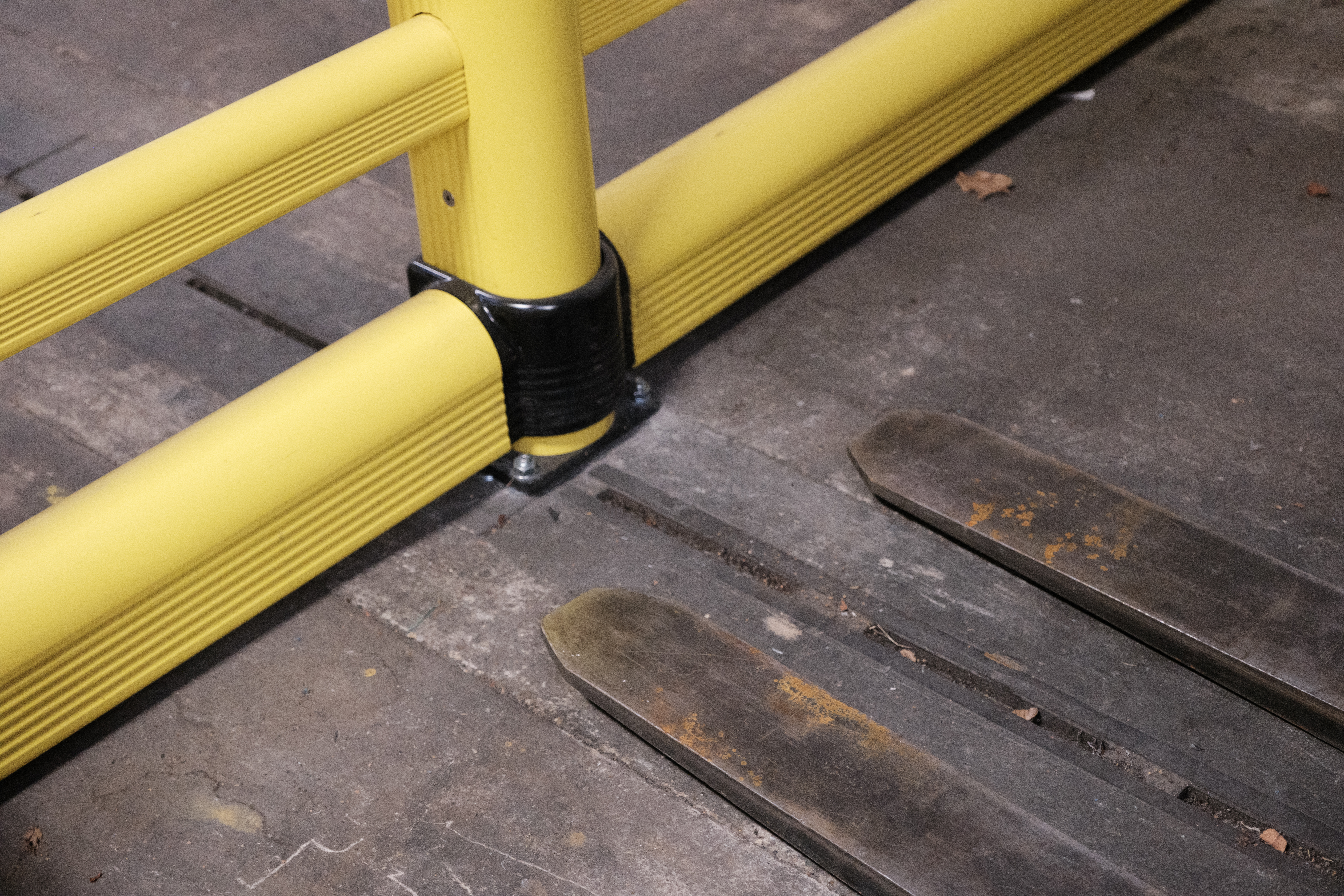 Detail shot of FLT forks adjacent to polymer safety barrier demonstrating collision risk area